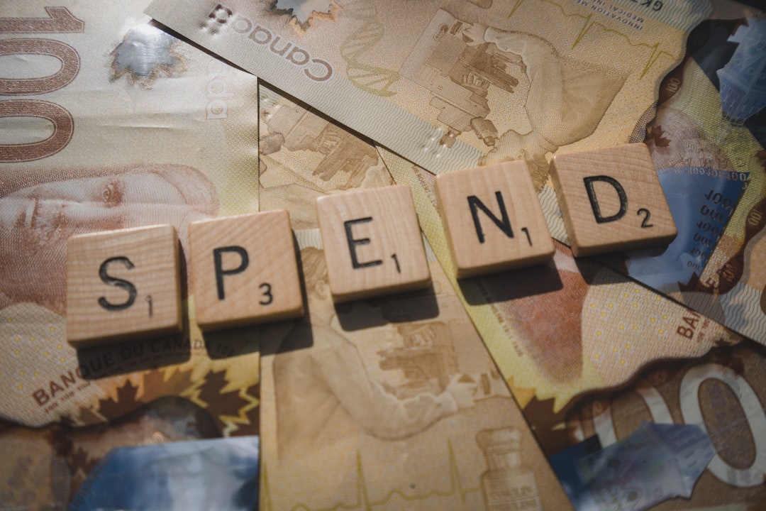 Scrabble letters spelling spend, on Canadian money 00 bills
